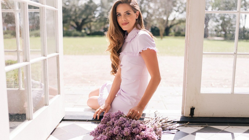 फूलों के साथ दरवाजे पर बैठी महिलाएं