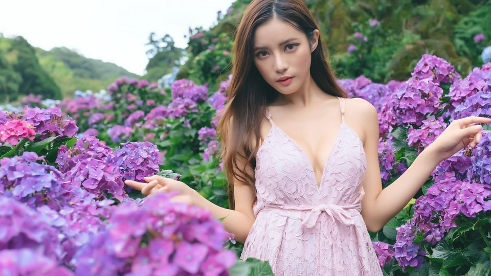 बैंगनी फूल क्षेत्र में एशियाई लड़की