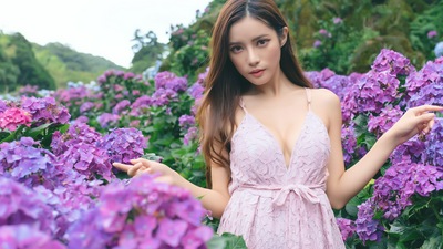 बैंगनी फूल क्षेत्र में एशियाई लड़की